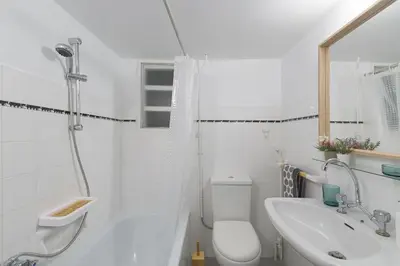 a white bathroom with a shower and a sink at Sunny Central Luxury 50 sm with balcony view 4th floor in Athens