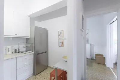 a kitchen with white cabinets and a refrigerator at Sunny Central Luxury 50 sm with balcony view 4th floor in Athens