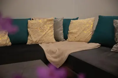 a couch with pillows and a blanket on it at Moon Haven Near Acropolis with 100Mbps WiFi in Athens
