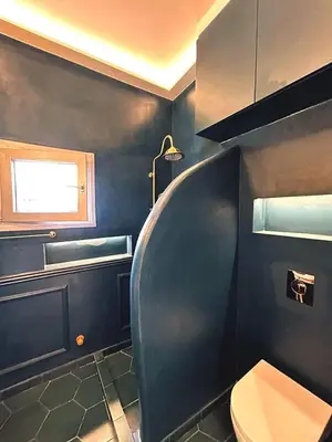 a blue bathroom with a toilet and a window at Boutique3436 Luxury Apartment in Athens