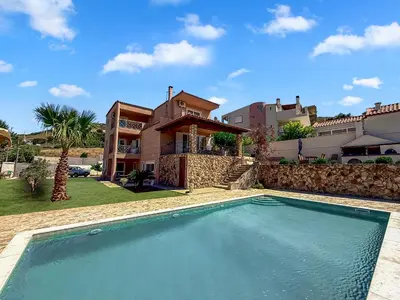 a villa with a swimming pool in front of a house at Escape pool villa in Anavissos in Athens