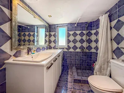 a blue tiled bathroom with a toilet and a sink at Escape pool villa in Anavissos in Athens