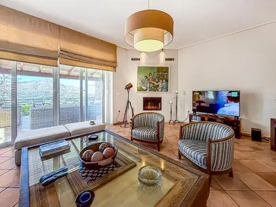 a living room with a couch and a tv at Escape pool villa in Anavissos in Athens