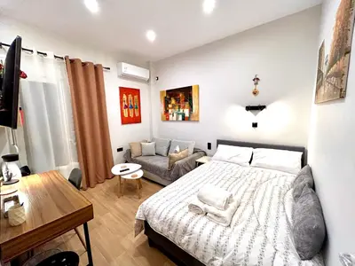 a bedroom with a large bed and a couch at Elegant & Stylish 2nd Floor Flat - 3' from Metro in Athens