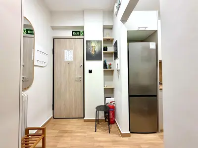 a hallway with a door and a table and a refrigerator at Elegant & Stylish 2nd Floor Flat - 3' from Metro in Athens