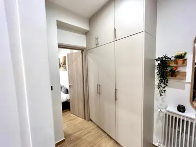 a hallway with white cabinets in a white apartment at Elegant & Stylish 2nd Floor Flat - 3' from Metro in Athens