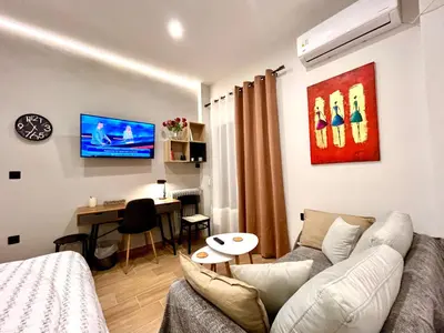 a living room with a couch and a desk in it at Elegant & Stylish 2nd Floor Flat - 3' from Metro in Athens
