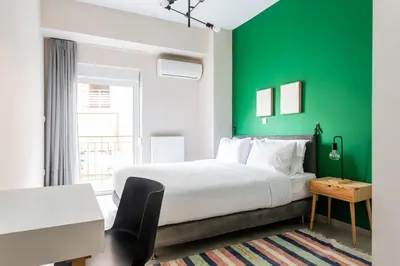 a bedroom with a bed and a green wall at Snug by Zoia Living in Athens