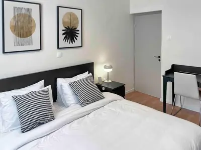 a bedroom with a white bed with pillows and a desk at Flat in Thissio in Athens