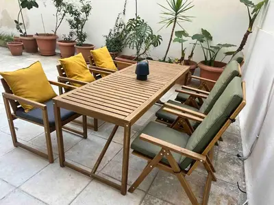 a wooden table with four chairs and a vase on it at Flat in Thissio in Athens
