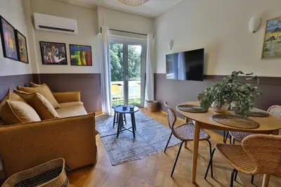 a living room with a table and a couch at Cosy apartment in Glyfada in Athens