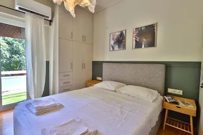 a bedroom with a large bed and a window at Cosy apartment in Glyfada in Athens