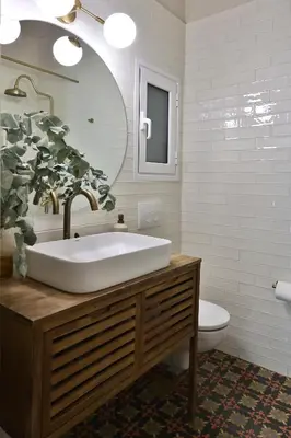 a bathroom with a sink and a toilet and a mirror at Cosy apartment in Glyfada in Athens