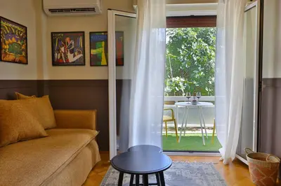 a living room with a couch and a table at Cosy apartment in Glyfada in Athens