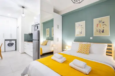 a bedroom with a large bed with yellow and blue walls at Athens Gem Retreat in Athens