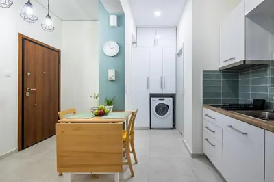a kitchen with a table and a washing machine at Athens Gem Retreat in Athens