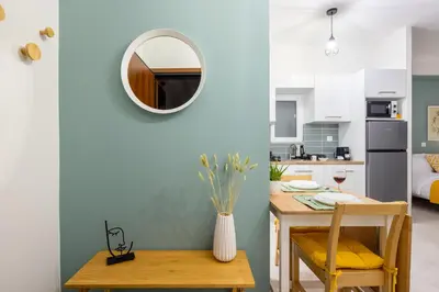 a kitchen and dining room with a table and a mirror at Athens Gem Retreat in Athens