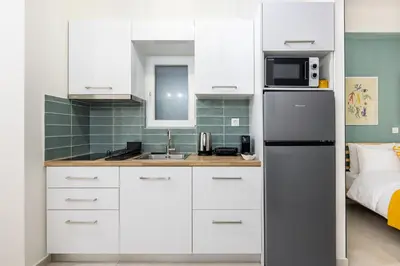 a kitchen with white cabinets and a refrigerator at Athens Gem Retreat in Athens