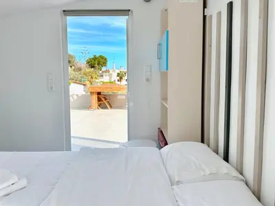 a bedroom with a bed and a view of a patio at Kasaj Luxury Apartments in Porto Rafti