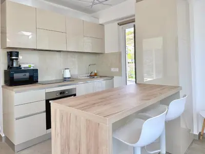 a kitchen with a wooden counter and white cabinets at Kasaj Luxury Apartments in Porto Rafti