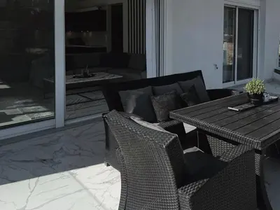 a dining table and chairs in a living room at Kasaj Luxury Apartments in Porto Rafti