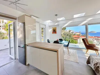 a kitchen and living room with a view of the ocean at Kasaj Luxury Apartments in Porto Rafti