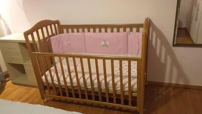 a crib with a pink blanket on top of it at Spacious flat ideal for families in Athens