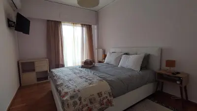 a bedroom with a large bed and a window at Spacious flat ideal for families in Athens