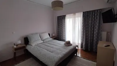 a bedroom with a bed and a large window at Spacious flat ideal for families in Athens
