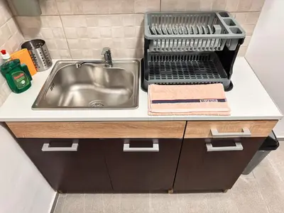 a kitchen counter with a sink and a dish drying rack at Kallithea Zen Studios-Near Filopappou & Koukaki in Athens
