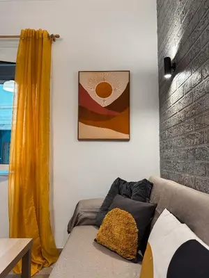a living room with a couch and a yellow curtain at Kallithea Zen Studios-Near Filopappou & Koukaki in Athens