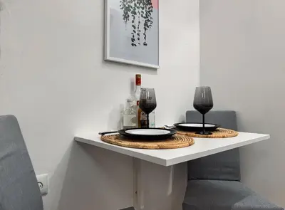 a table with two plates and wine glasses on it at Kallithea Zen Studios-Near Filopappou & Koukaki in Athens