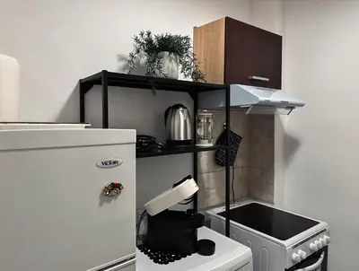 a miniature kitchen with a stove and a refrigerator at Kallithea Zen Studios-Near Filopappou & Koukaki in Athens