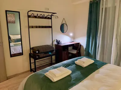 a bedroom with a bed with a desk and a mirror at Mint Luxury Residence in Spáta