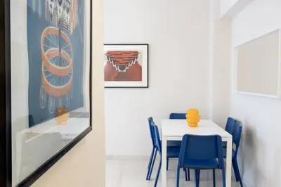 a dining room with a white table and blue chairs at Superb Family Apt In The Center Of Athens in Athens