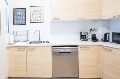 a kitchen with wooden cabinets and a stainless steel dishwasher at Superb Family Apt In The Center Of Athens in Athens