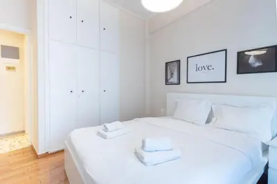 a bedroom with a white bed with towels on it at Superb Family Apt In The Center Of Athens in Athens