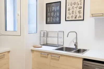 a kitchen with a sink and some pictures on the wall at Superb Family Apt In The Center Of Athens in Athens