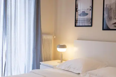 a bedroom with a bed with a lamp and a window at Superb Family Apt In The Center Of Athens in Athens
