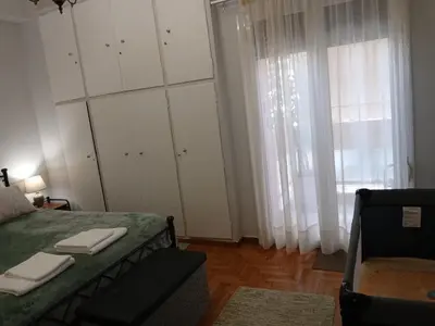 a bedroom with a bed and a couch and windows at FeelAthens36 - very close to Syntagma, city center in Athens