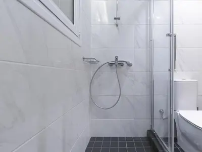 a bathroom with a shower with a glass door at Modern Haven near Archaeological Museum in Athens