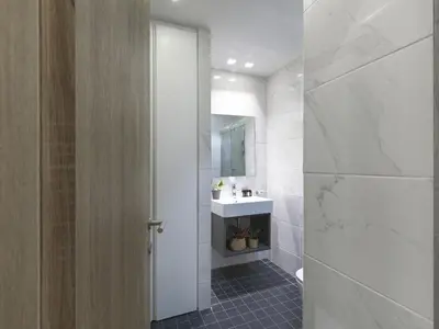 a bathroom with a sink and a toilet and a mirror at Modern Haven near Archaeological Museum in Athens