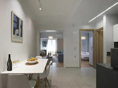 a kitchen and living room with a white table and chairs at Modern Haven near Archaeological Museum in Athens