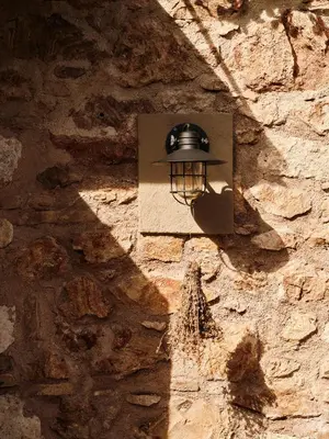 a light on the side of a stone wall at Not Boutique Hotel in Athens
