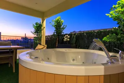 a bath tub sitting on top of a patio at Aiolos Rooftop JUCCUZI with view near the centre NEA smyrni in Athens