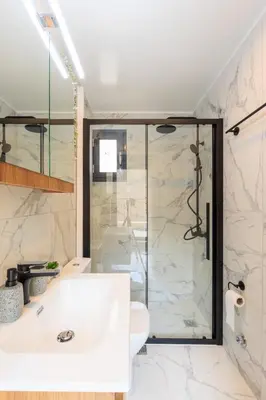 a bathroom with a shower and a white sink at Aiolos Rooftop JUCCUZI with view near the centre NEA smyrni in Athens