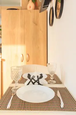 a table with a plate and two glasses on it at Aiolos Rooftop JUCCUZI with view near the centre NEA smyrni in Athens