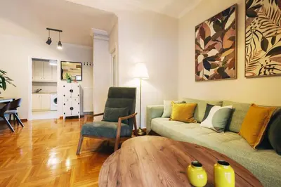 a living room with a couch and a table at Bright 2 bdr Pagrati apartment in Athens