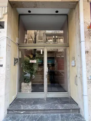 an entrance to a store with glass doors at Bright 2 bdr Pagrati apartment in Athens