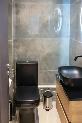 a bathroom with a black toilet and a sink at Apartment in Athens Neos Kosmos in Athens